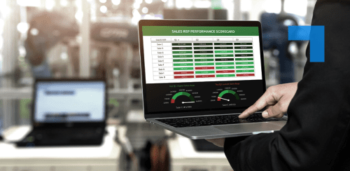 Business professional analysing a sales performance dashboard on a laptop in a manufacturing environment.
