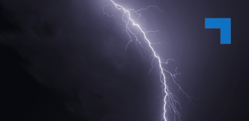 A bolt of lightning illuminates a dark sky.