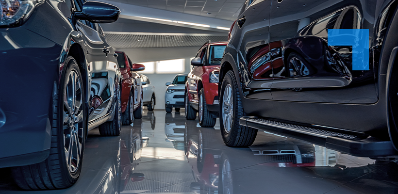 Several cars parked in a well-lit showroom, viewed from a low angle along the showroom floor.