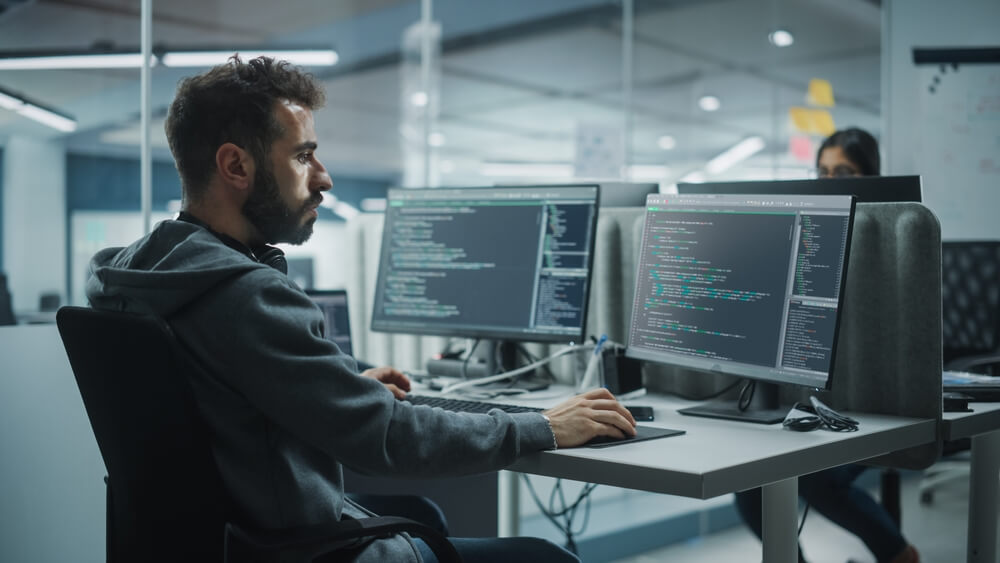 business man working on computer at desk in a software company office