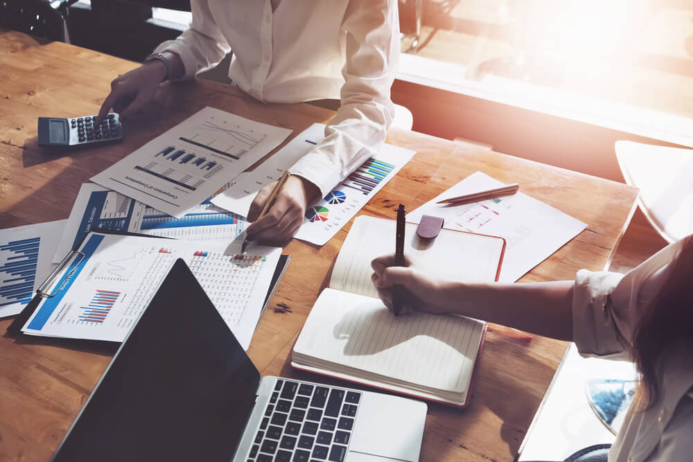 business sales advisers providing financial advice working at a desk in an office
