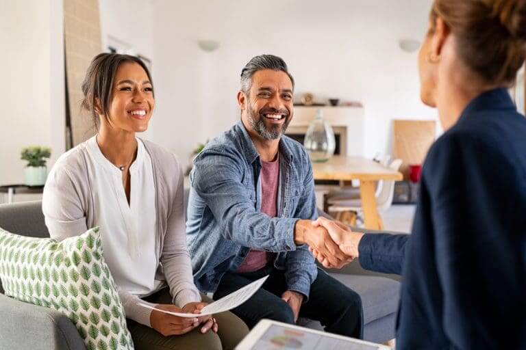 business sales adviser working with two clients shaking hands in an office