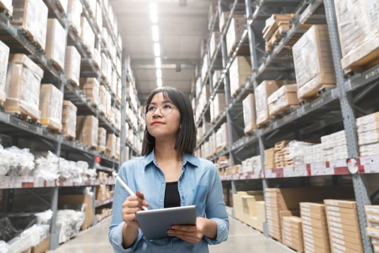 Retail manager conducting inventory checks in a warehouse to assess business performance and value