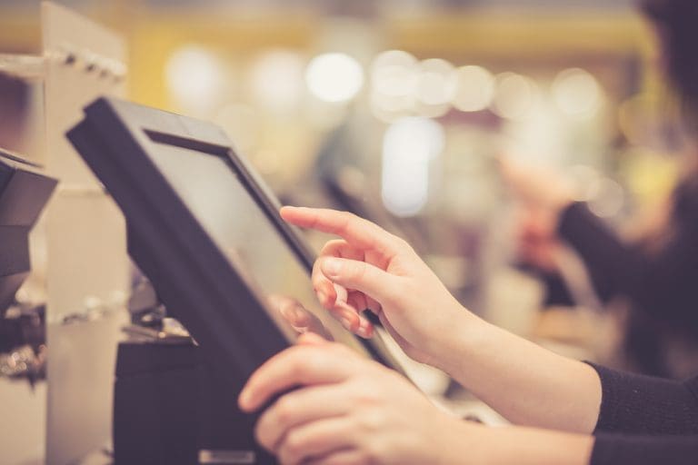 Retail professional using a point-of-sale system to manage sales and business performance