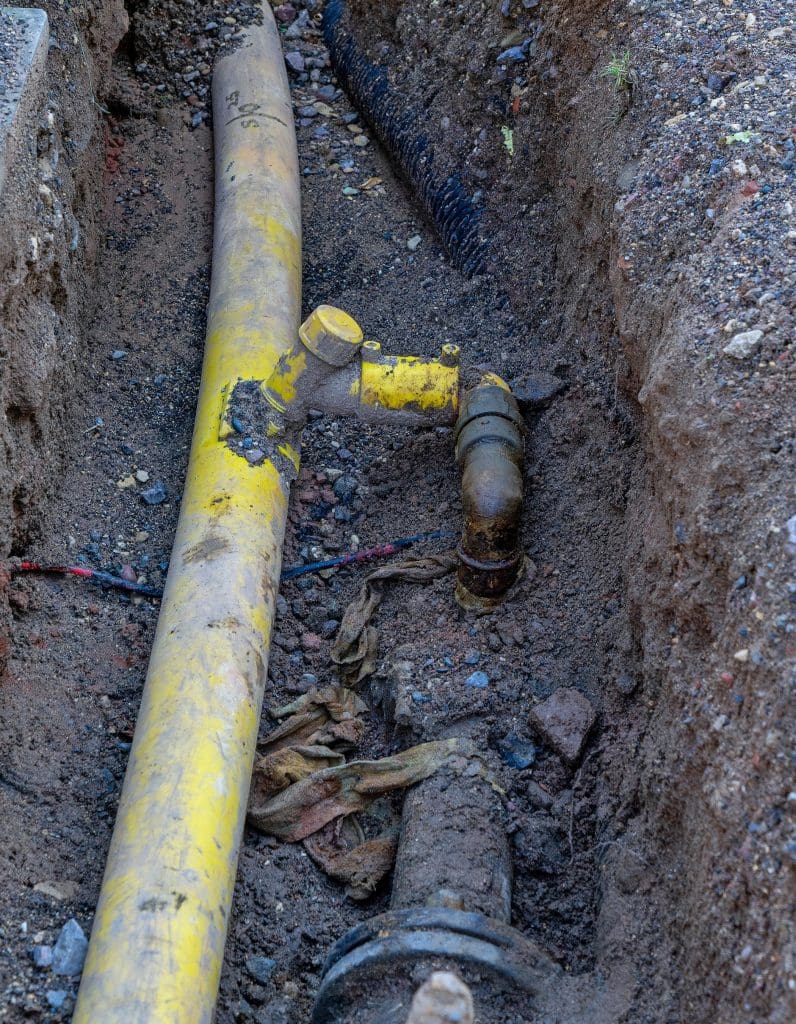 Open excavation including exposed yellow pipe