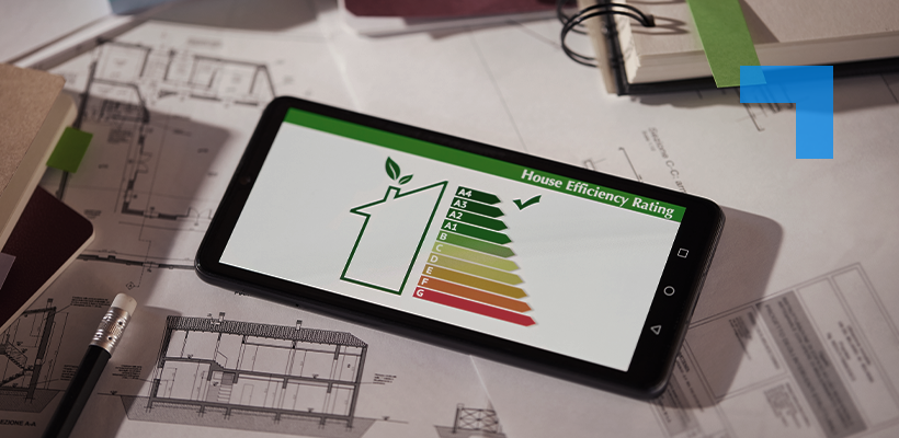 A smartphone displaying a House Efficiency Rating chart with colour-coded bands from green (A) to red (G) and a tick mark at the top rating, resting on architectural building plans alongside a pencil.