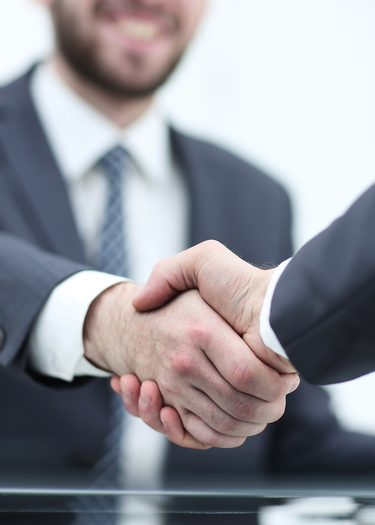 A business sales adviser seals the deal with a firm handshake after reaching a mutual agreement on a profitable business sale.
